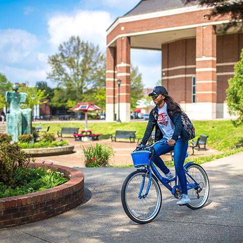 Student bikes past Green Man on in UC plaza